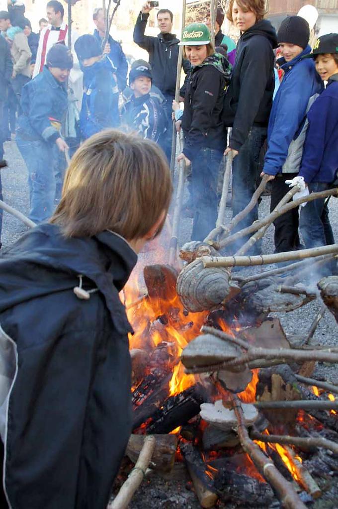 Die Schwammstecken kommen ins gesegnete Feuer Ausschwärmen der Buben mit ihren glimmenden Stecken