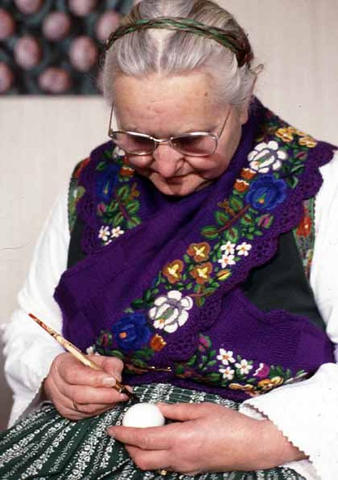 Eine Frau in Tracht bemalt in Hessen Ostereier. Ostereierrollen in Aurich / Friesland.