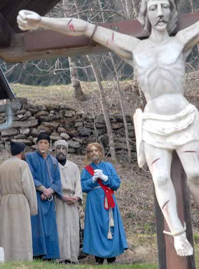 Jesus und seine Lieblingsapostel, alle maskiert, vor dem Ulrichskirchlein in Tresdorf. Im Vordergrund ein großes Kruzifix.