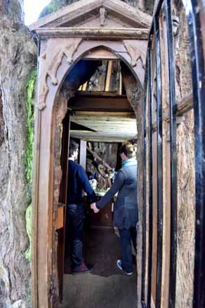 Zwei Touristen stehen vor dem Marienaltar in der Baumkapelle in La Haye-du-Routot 