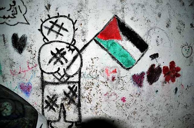 Graffito im Flüchtlingslager Deheishe von Naji al-Ali. Handala mit palästinensischer Fahne