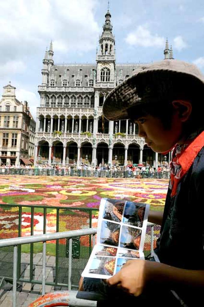 Ein japanischer Junge blättert in Katalog zum Blumenteppich Ein japanischer Junge blättert in Katalog zum Blumenteppich