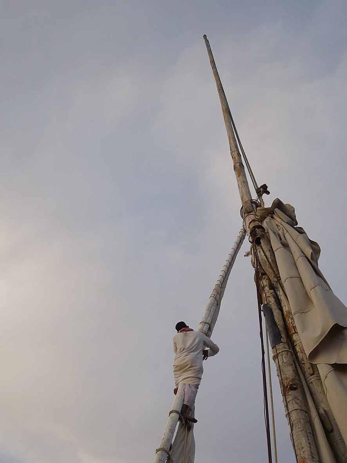 Das Reffen & Zusammenbinden des Segels für die Nacht erfordert akrobatische Kletterkünste Das Reffen & Zusammenbinden des Segels für die Nacht erfordert akrobatische Kletterkünste