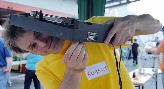 Robert vom Repair-Cafe Team bemüht sich um den Plattenspieler von Gottfried Bartjes Reparaturversuche an einem koreanischen Reisschnellkochtopf