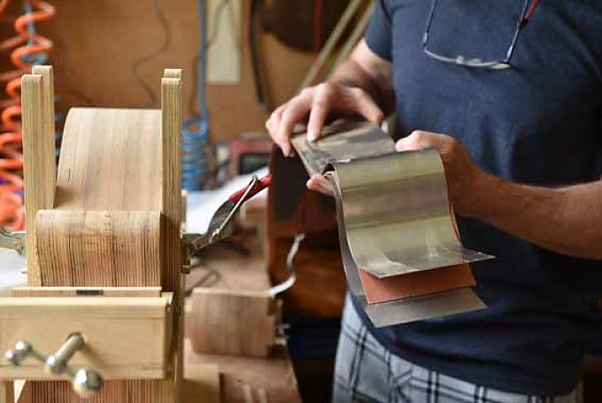 Am Fenster steht die „Side binding machine“. An diesem Gerät spannt Laurie Holzbretter für die Zargen ein, die Seitenteile der Instrumente. Am Fenster steht die „Side binding machine“. An diesem Gerät spannt Laurie Holzbretter für die Zargen ein, die Seitenteile der Instrumente.