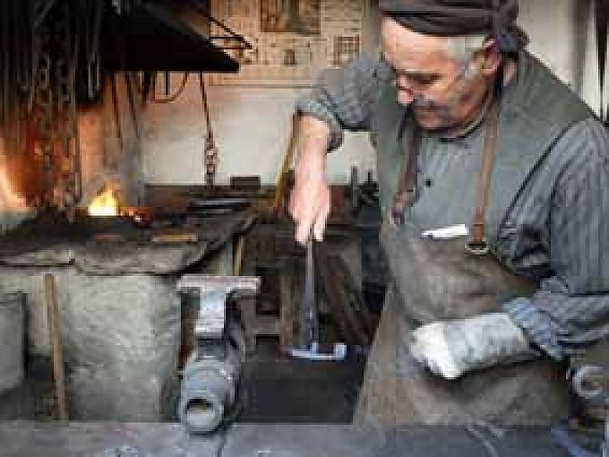 Davide Bondolfi in der Schmiede. Loreta Ferrari-Zanetti in der Casa Tome.