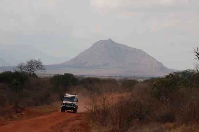 Touristen unterwegs in einem Jeep im privaten Schutzgebiet am Rande des Tsavo Nationalparks in Kenia. Touristen unterwegs in einem Jeep im privaten Schutzgebiet am Rande des Tsavo Nationalparks in Kenia.