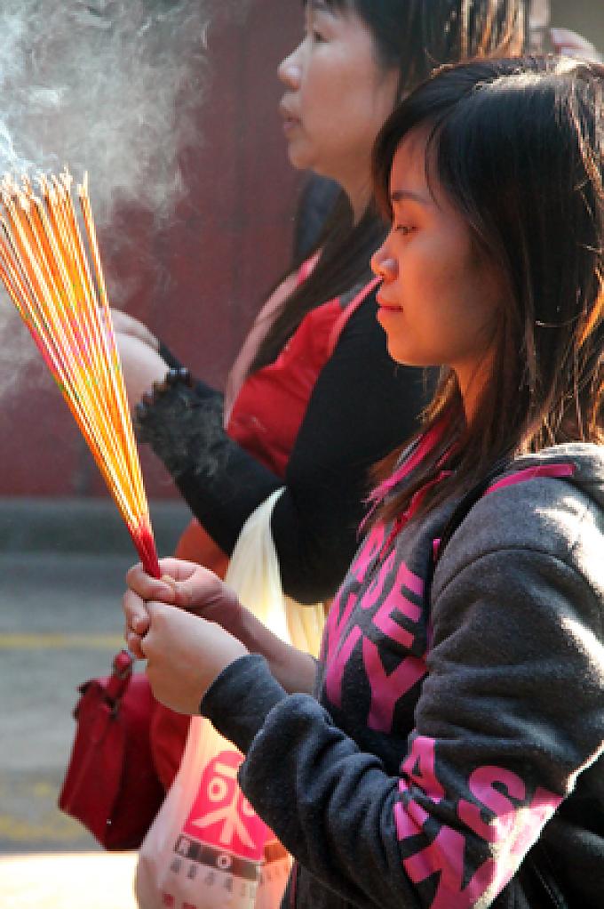 Betende halten Räucherstäbchen in den Händen im A-Ma Tempel. Farol da Guia.