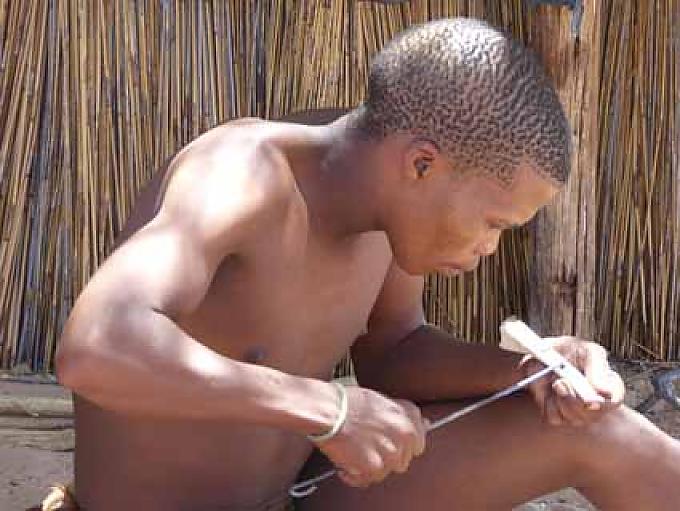 Konzentrierter San-Künstler bei der Arbeit Konzentrierter San-Künstler bei der Arbeit