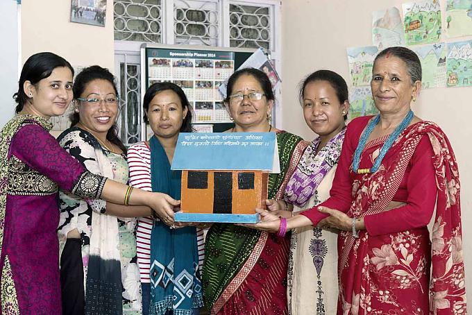 Das Modell eines Hauses wird als Forderung nach Bleiberecht übergeben "Slum-Committee" im Gemeinschaftsraum