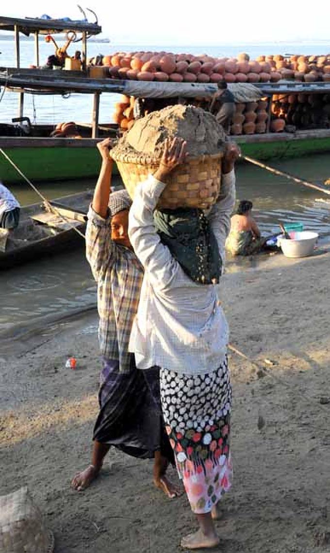 Wins große Schwester Youn (l.) trägt schweren Körbe mit Sand Wins große Schwester Youn (l.) trägt schweren Körbe mit Sand