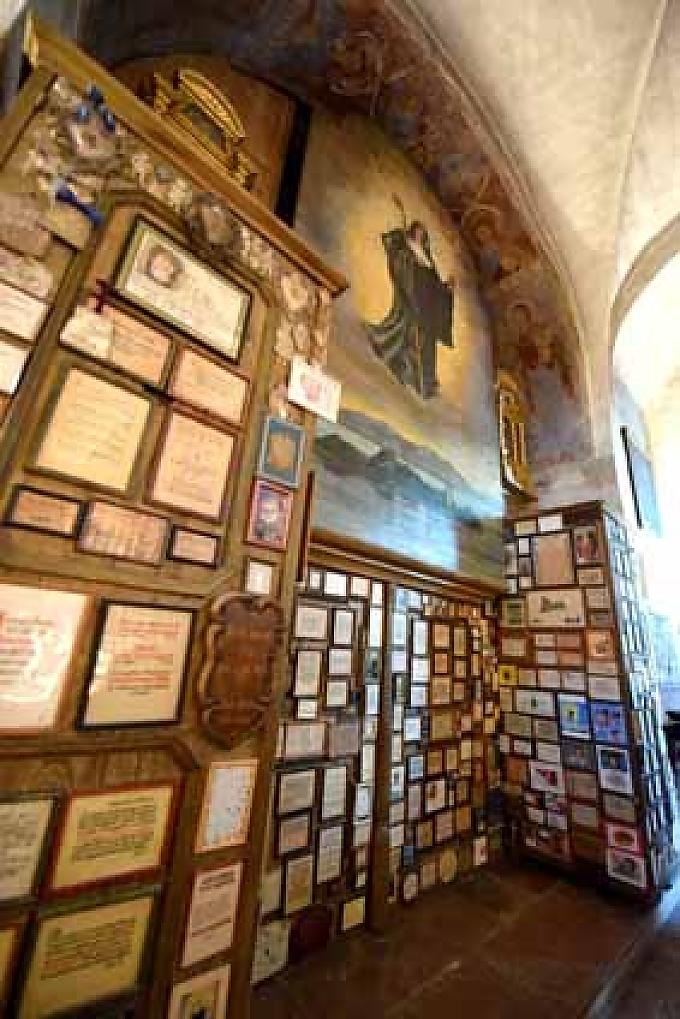 Gläubigen beten unter dem großen Gemälde, auf dem die Selige Irmgard schwebend über der Insel Frauenchiemsee mit einer Krone dargestellt wird. Gläubigen beten unter dem großen Gemälde, auf dem die Selige Irmgard schwebend über der Insel Frauenchiemsee mit einer Krone dargestellt wird.