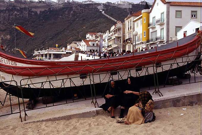 Einwohner von Nazare sitzen am Strand Einwohner von Nazare sitzen am Strand