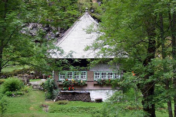 Uhremacherhaus mit großen Fenstern Uhrenträger Albrecht Seng in historischer Tracht.
