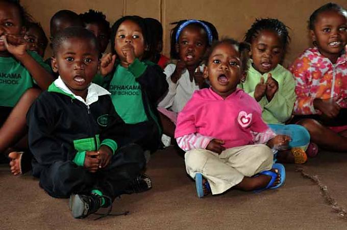 Sophakama Pre-School am Rande des Townships. Aidswaisen singen Reime und Lieder. Siobhan (M.) unterwegs in Kleinskool, einem armseligen Township am Ostkap