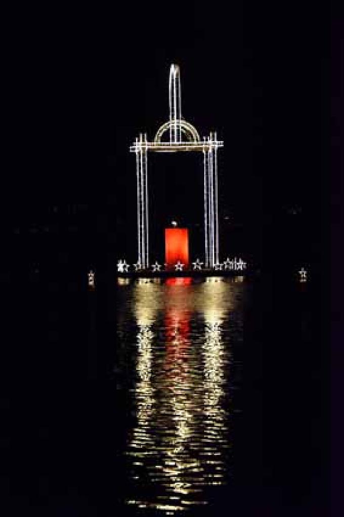 Friedenslichtlaterne vor St. Wolfgang. Krippe in St. Wolfgang. Zentrum des Adventsmarktes ist die begehbare lebensgroße Krippe im Pfarrgarten vom Holzbildhauer Matthäus Mayrhauser.