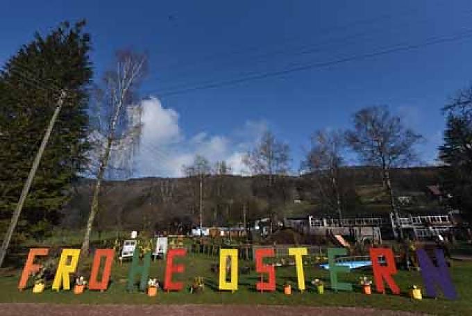 In großen bunten Holzbuchstaben steht im Park „Frohe Ostern“. In großen bunten Holzbuchstaben steht im Park „Frohe Ostern“.