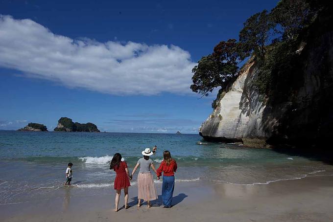 Bis zu den Knien im Wasser stehen drei Asiatinnen und lassen sich fotografieren. Bis zu den Knien im Wasser stehen drei Asiatinnen und lassen sich fotografieren.