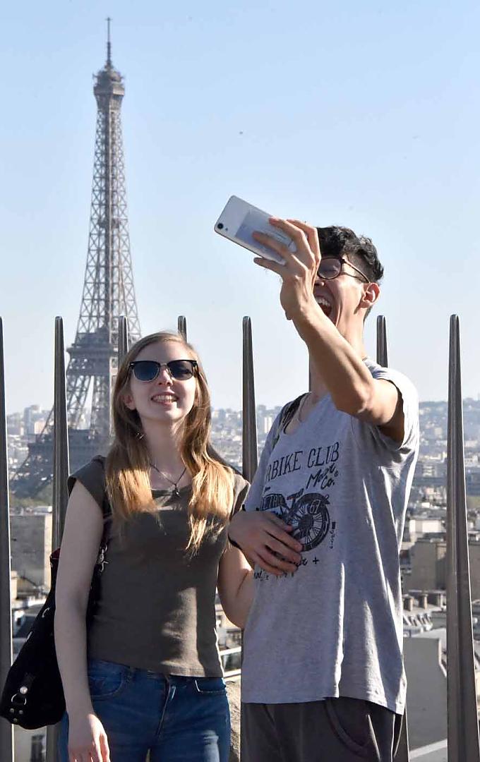 Besucher machen ein Selfie mit Eiffelturm vom Arc de Triomphe. Der Arc de Triomphe.
