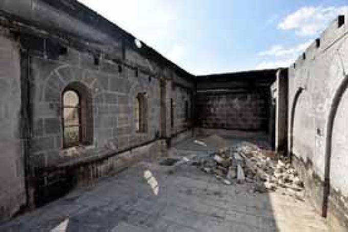 Zerstörte Räume in Tabgha  Benediktinerpater Matthias mit Besuchern