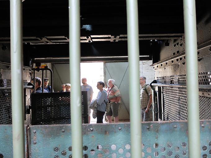 Besucher im Museum. Langsam, ganz langsam müht sich die schmale Bahn auf ihrer 600 Millimeter breiten Spur durch den Wald hinauf. In den offenen Waggons sitzen die Besucher auf einfachen Holzbänken.
