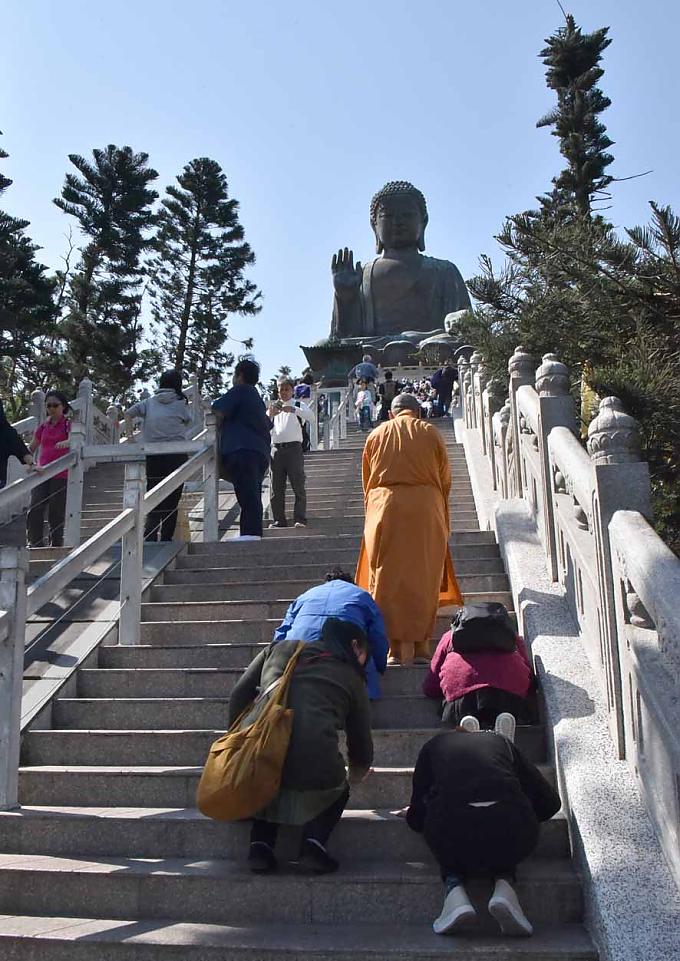 Betend steigen die Pilger die Stufen zur Buddha-Statue hinauf. 