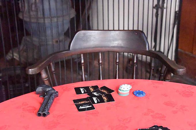 Ein Stapel Karten, Jetons und gleich daneben ein Revolver – der Spieltisch im Saloon lässt erkennen, dass es in diesem Raum einmal hoch herging.