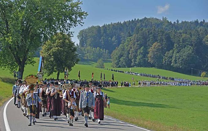 Nach dem Schlusssegen formiert sich der Zug, und es geht durch die Wiesen wieder hinunter Richtung Festzelt. Frau in Tracht