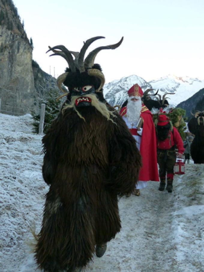 Krampus-Passe samt Nikolaus im Anmarsch Krampus-Gestalt in verschneiter Landschaft