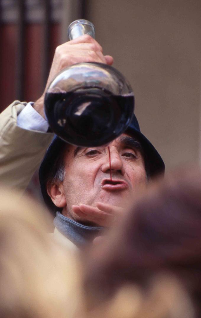 Ein Spanier trinkt Wein aus einem porron, einer katalanischen Trinkflasche Eine Frau in katalanischer Tracht