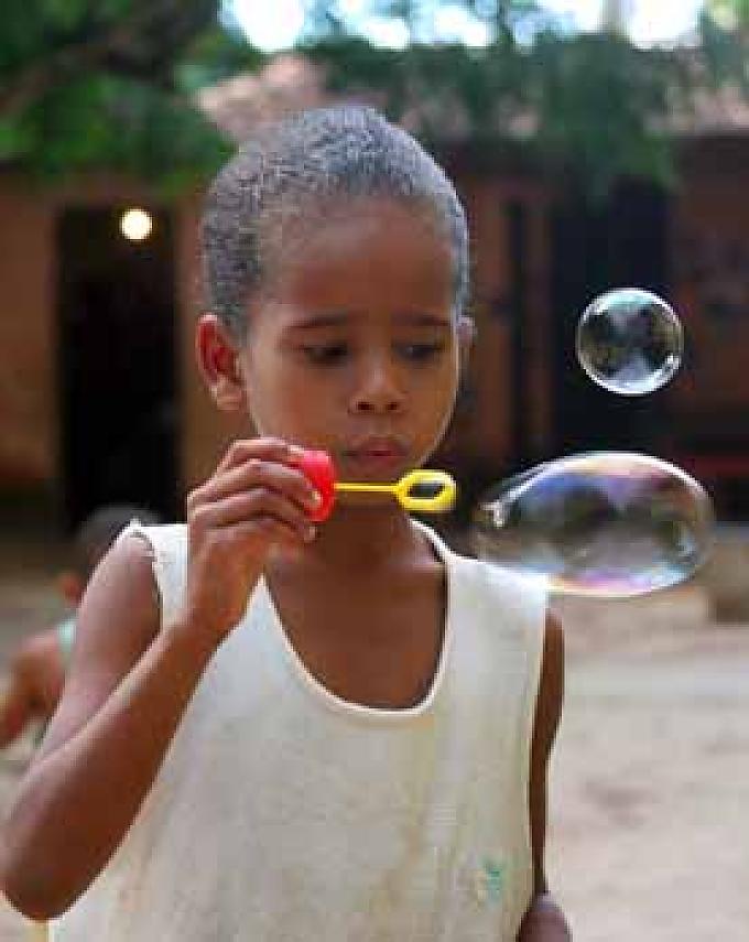 Ein Mädchen produziert während des Spieltreffs Seifenblasen. Ein Junge beim Spieltreff.