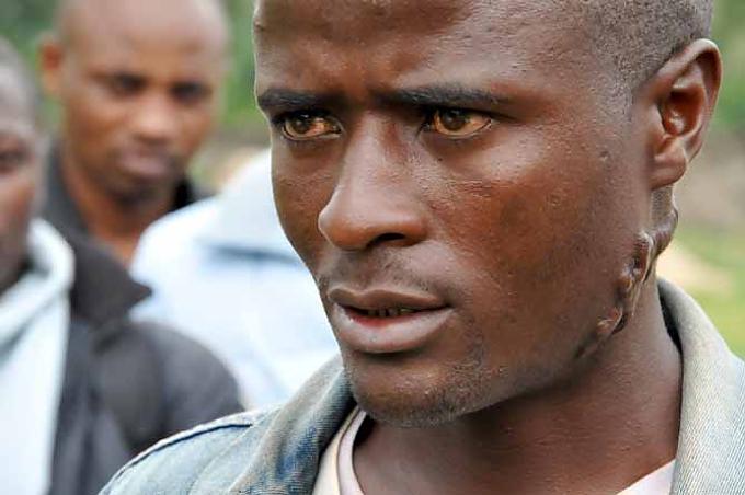 Sinbikubwabo während der Diskussion auf dem Bolzplatz des Dorfes Zuschauerin in Njundo