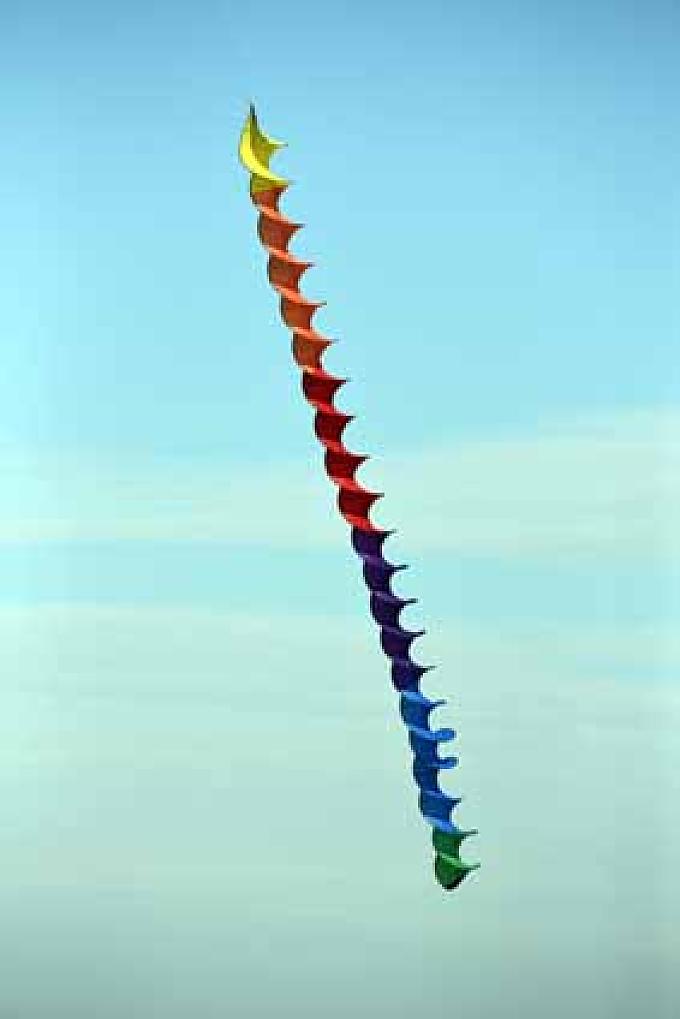 Bunte Spirale als Leinenschmuck. Jan versucht seinen Drachen, einen kleinen schwarzen Raben, zu starten.