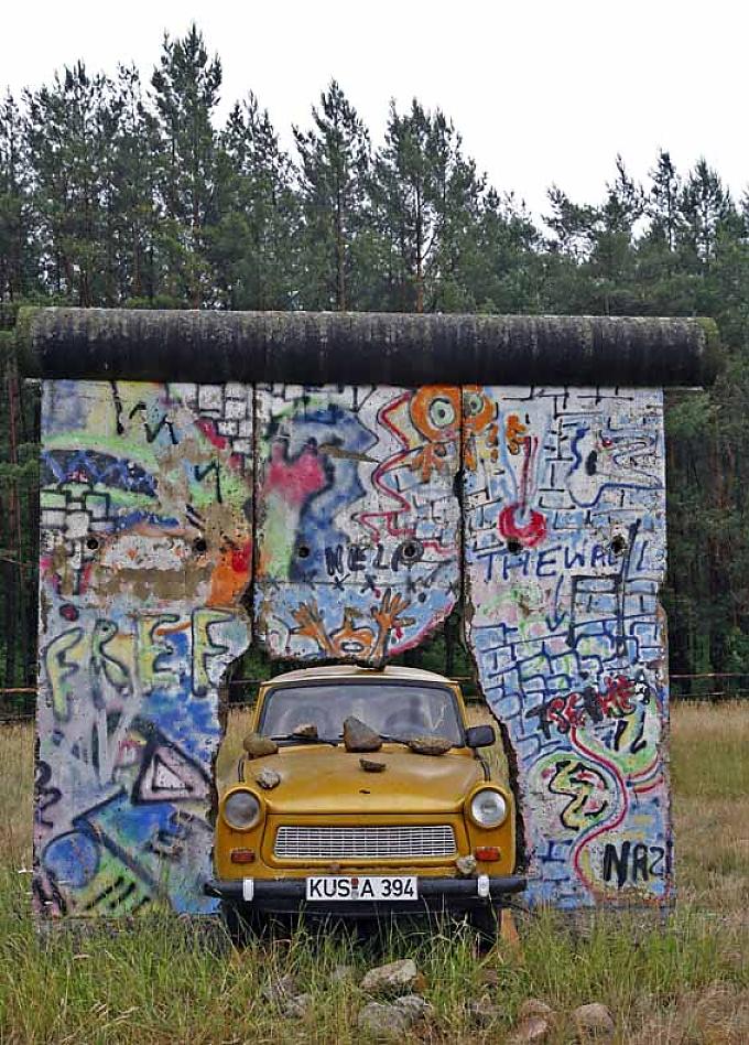 "Goldene Zukunft" heißt die Kunst-Installation von Zahnarzt Ludwik Wasecki, in der ein Trabant die 3,6 Meter hohen Elemente der Berliner Mauer durchbricht Die Malereien auf den Mauersegmenten stammen von dem Künstler Thierry Noir