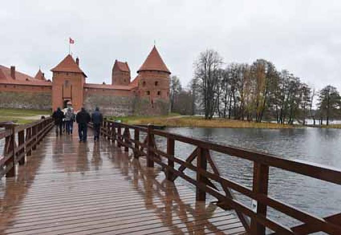 Über einen langen Holzsteg geht es über den Galvėsee auf die kleine Insel mit der Burg Gobelin zeigt die Rückkehr der Ritter aus der Schlacht bei Tannenberg im Jahr 1410.