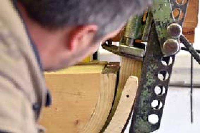 Florim spannt die für Schlittenkufen geeigneten Holzlatten aus Schweizer Esche in die Form ein. Gebogene Kufen