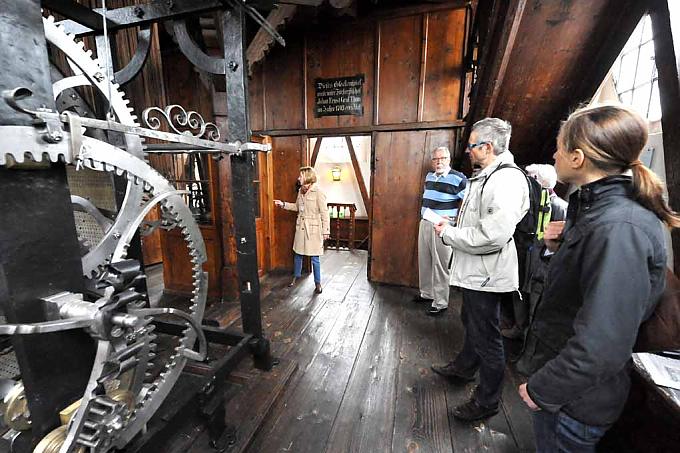 Besucher betrachten das historische Uhrwerk Besucher betrachten das historische Uhrwerk