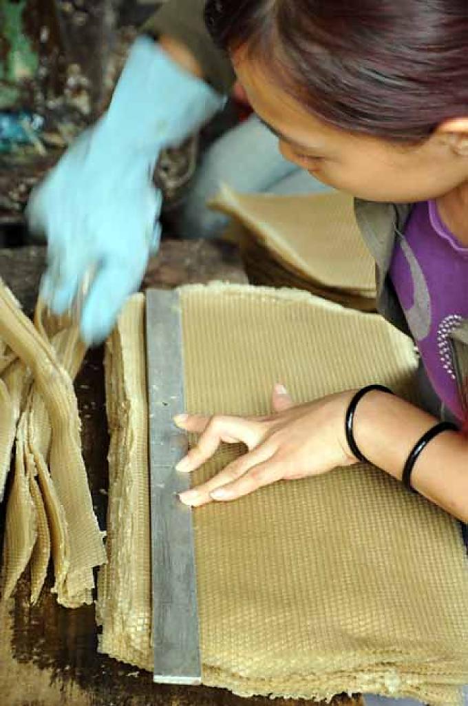 Die Waben werden im Stapel zu gleichmäßigen rechteckigen Stücken geschnitten. Die Waben werden im Stapel zu gleichmäßigen rechteckigen Stücken geschnitten.