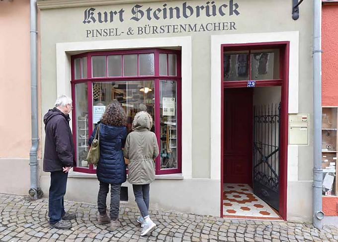 Interessierte schauen in die Auslage des Bürstengeschäftes von Ursula Römer. 