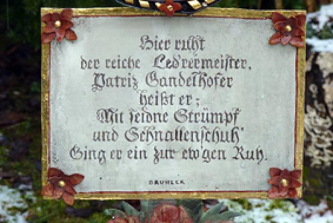 Der „reiche Led’rermeiser, Patriz Gandelhofer heißt er, mit seidne Strümpf und Schnallenschuh’ ging er ein zur ew’gen Ruh“. 