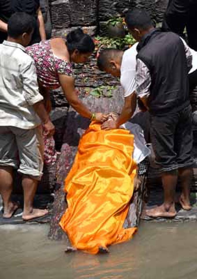 Vor der Verbrennung bespritzt man die Leiche mit dem Wasser des heiligen Flusses und wäscht die Füße im Wasser.
