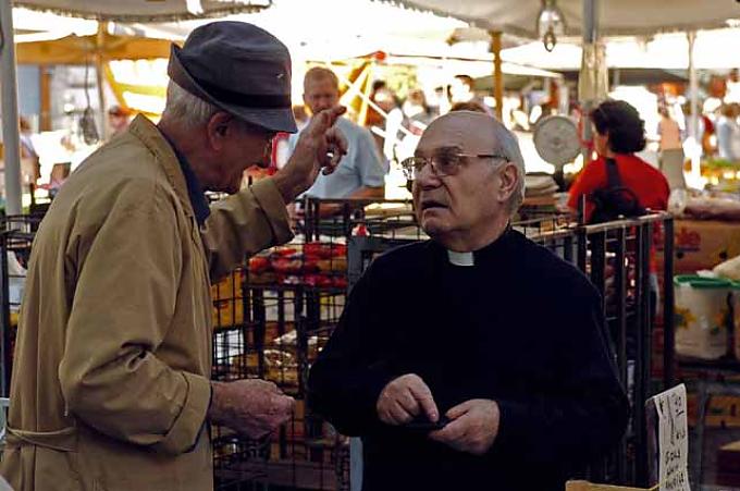 Ein Priester unterhält sich mit einem Händler Ein Priester unterhält sich mit einem Händler