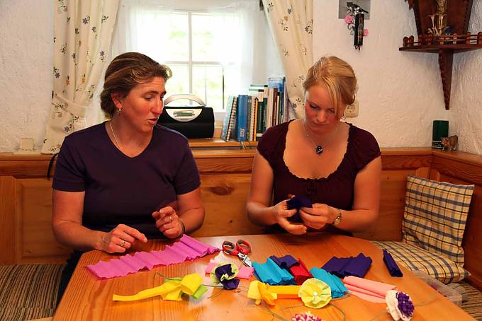 Maria Annet und Ingrid basteln emsig Blumen aus Krepppapiere für den Almabtrieb. Almführerin Marianne Willer.