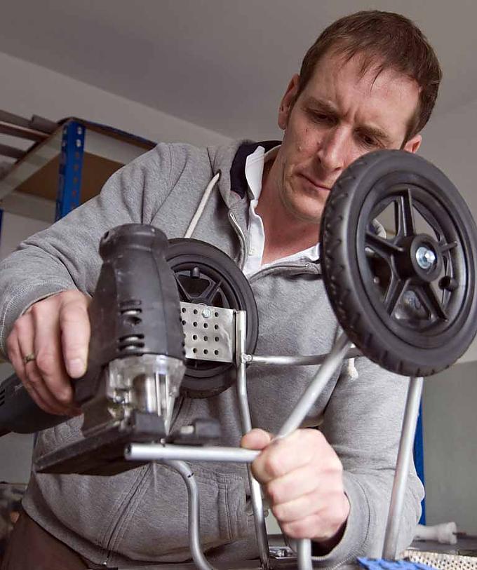 Markus van den Boom arbeitet mit einer Metallsäge an einem Hunderollwagen Markus van den Boom arbeitet mit einer Metallsäge an einem Hunderollwagen