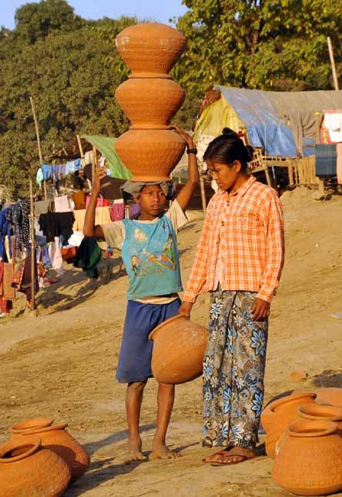 Win kleiner Bruder Shwe bei der Arbeit Wins große Schwester Youn (l.) trägt schweren Körbe mit Sand
