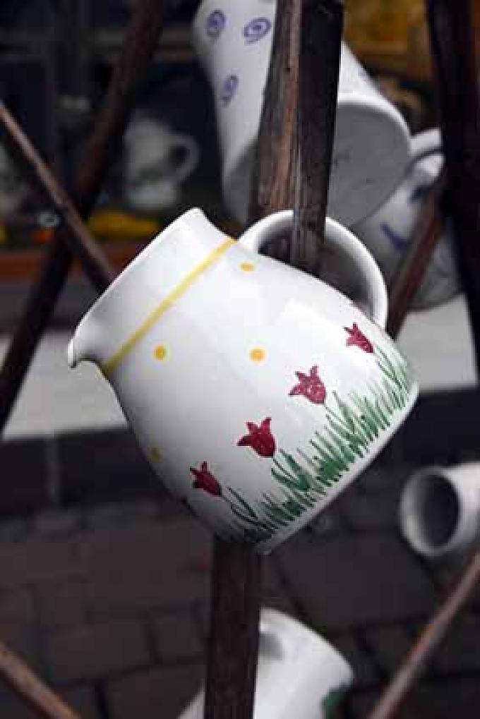 Vor dem Laden hängen die Krüge auf Holzgestellen. Vor dem Laden hängen die Krüge auf Holzgestellen.