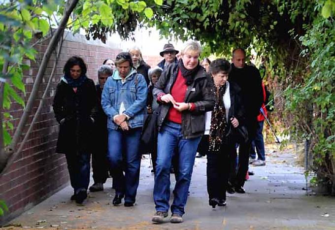 Mit tief gesenkten Häuptern folgen die Besucher ihrer Kräuterhexe. Alle achten auf die kleinen und großen Pflanzen am Wegesrand. Vorsichtig riechen die Besucher an Wurzeln.