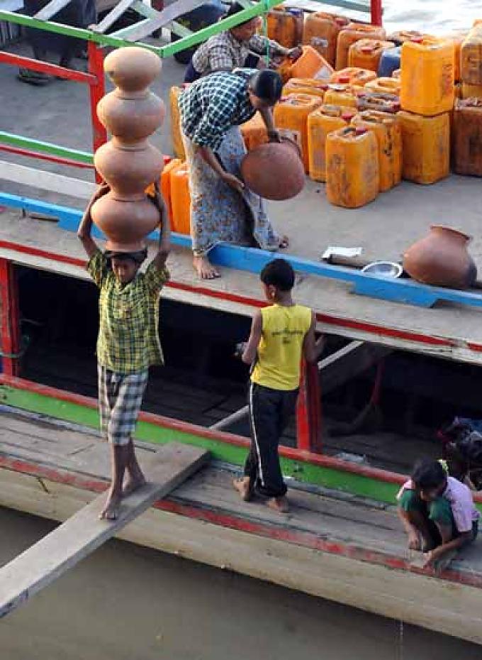 Lastenträger beim Entladen eines Frachtkahnes Wins große Schwester Youn (l.) trägt schweren Körbe mit Sand