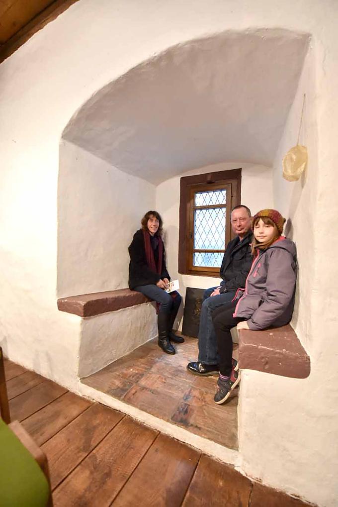 Familie in einer Fensternische mit Sitzbänken. Familie in einer Fensternische mit Sitzbänken.