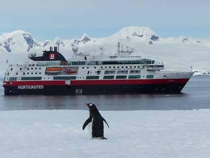Pinguin vor der MS Fram in Mikkelsen Harbour Eishöhle bei Cuverville Island